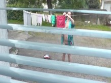 Vecino en bata de baño sin bragas y sostén se seca lavando patio, vecino mirando por la ventana